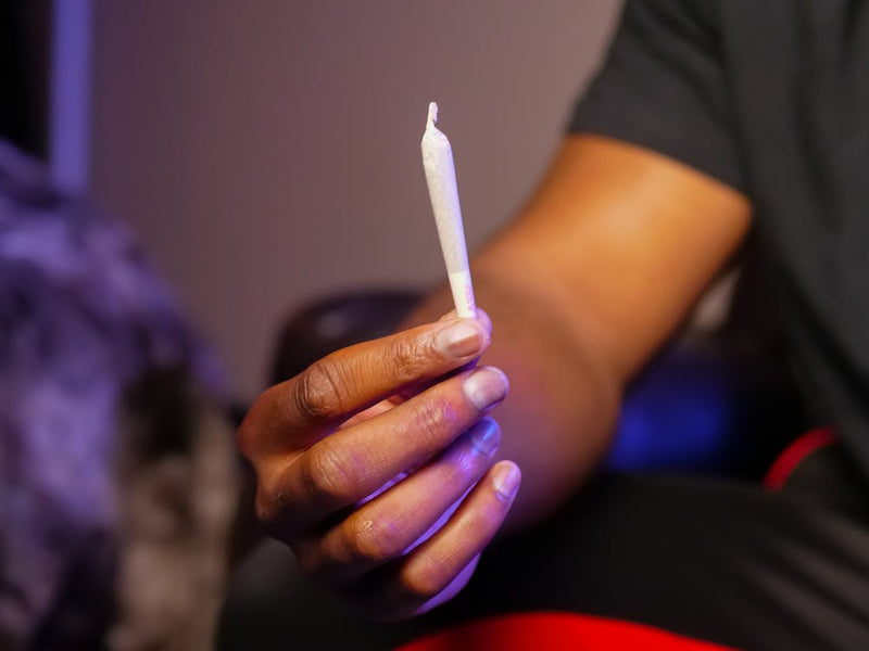 Man holding dispensary branded joint