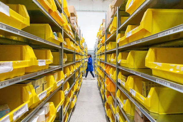 Dispensary inventory in yellow storage boxes on shelving